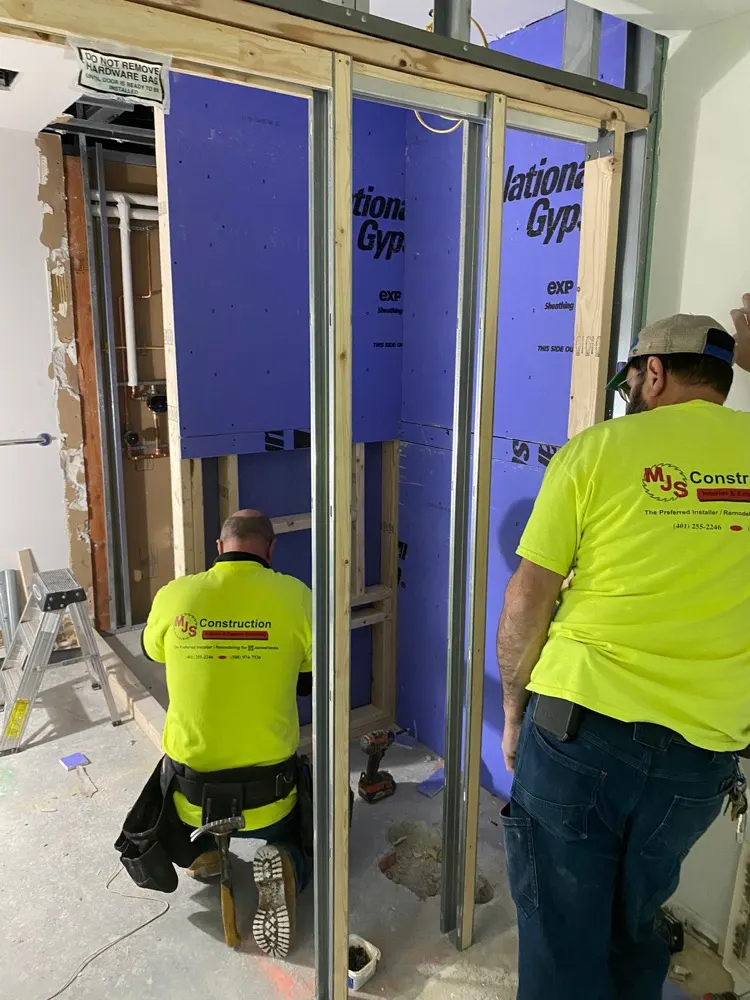 MJS crew members framing a wall in MJS hi-vis shirts